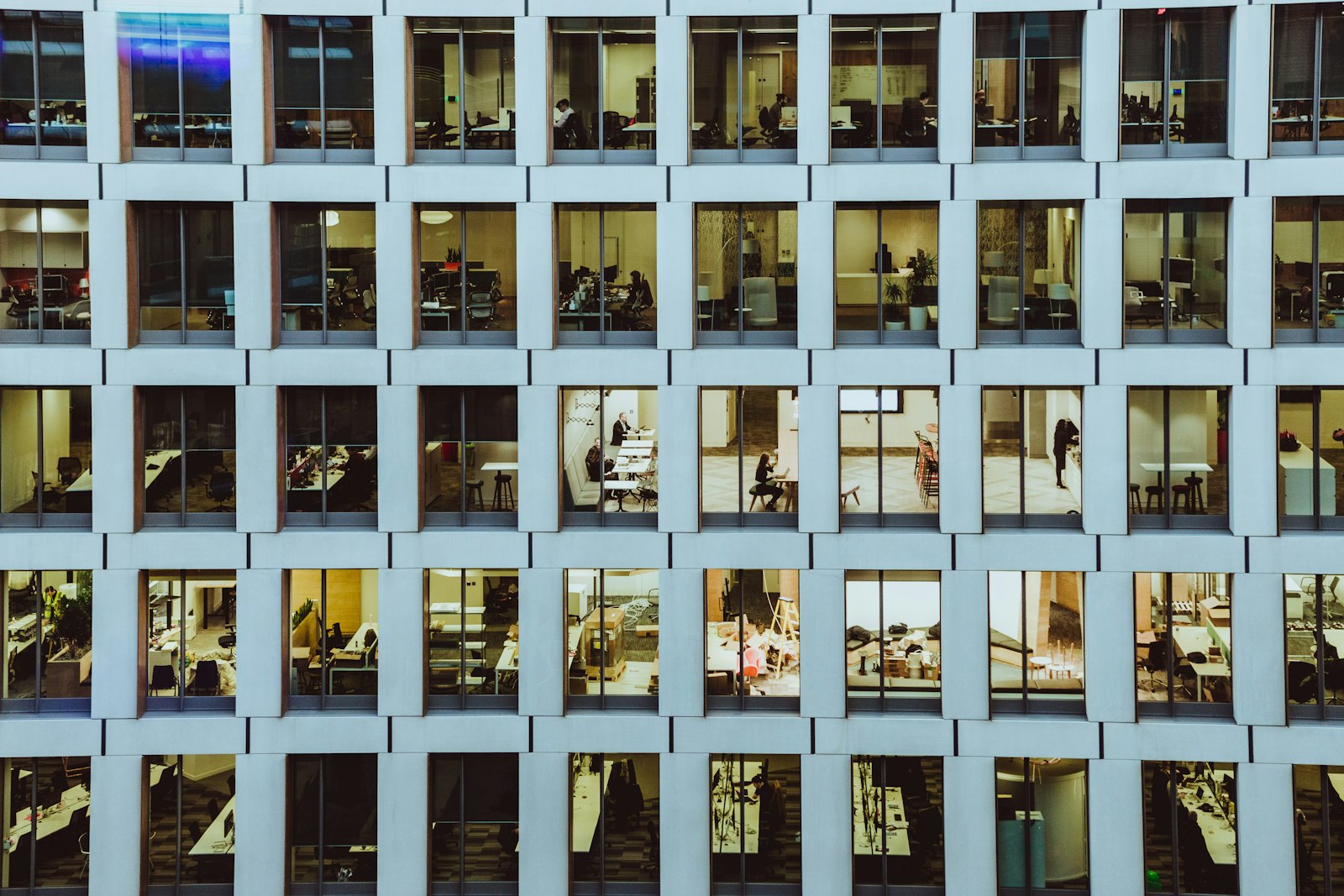 Rows of office windows in a modern building facade, showing many separate offices