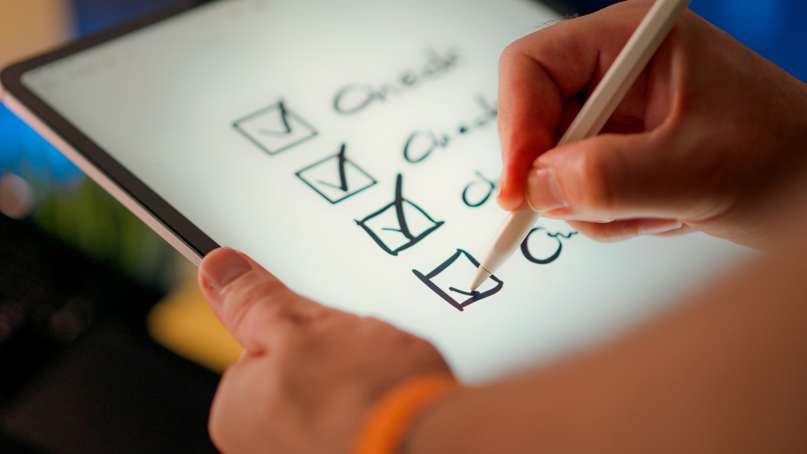 A hand using a stylus to check off items on a digital checklist
