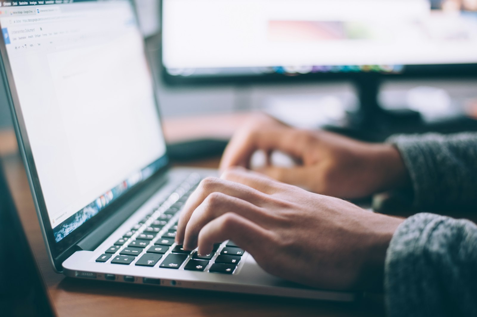 Close-up of hands typing on a laptop keyboard while searching job listings online